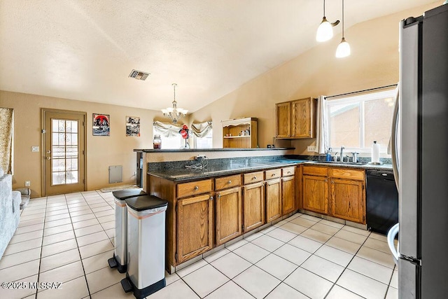 kitchen featuring decorative light fixtures, light tile patterned floors, stainless steel fridge, black dishwasher, and kitchen peninsula