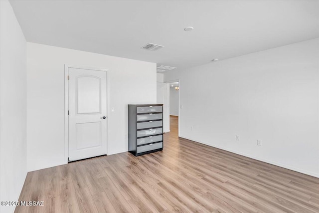 spare room with visible vents, light wood-style floors, and baseboards