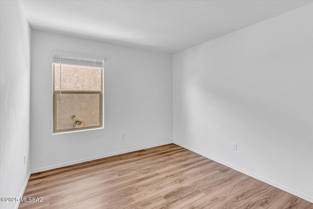 empty room with baseboards and wood finished floors