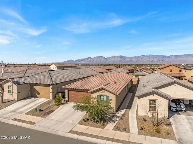 exterior space with a residential view, an attached garage, stucco siding, concrete driveway, and a tiled roof