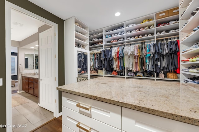 walk in closet featuring tile patterned flooring and sink