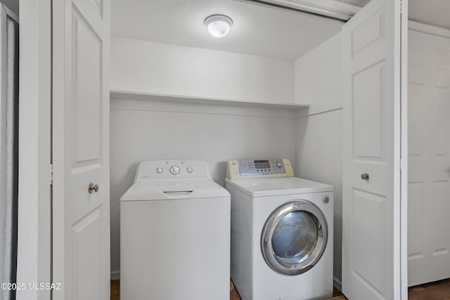 clothes washing area featuring separate washer and dryer