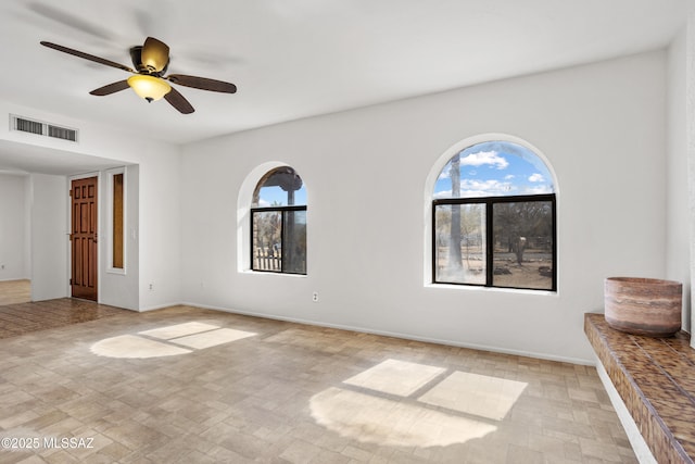 unfurnished room featuring a wealth of natural light and ceiling fan