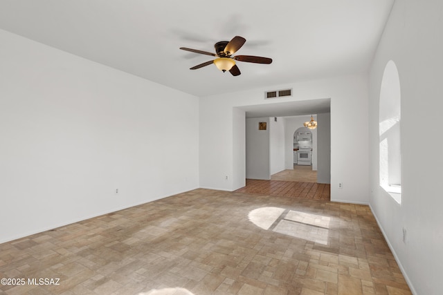 empty room with ceiling fan with notable chandelier