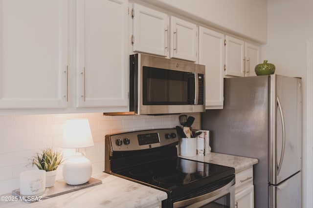 kitchen featuring tasteful backsplash, appliances with stainless steel finishes, and white cabinets