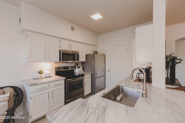 kitchen featuring backsplash, appliances with stainless steel finishes, sink, and white cabinets