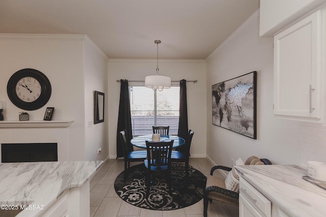 dining space featuring crown molding and a tile fireplace