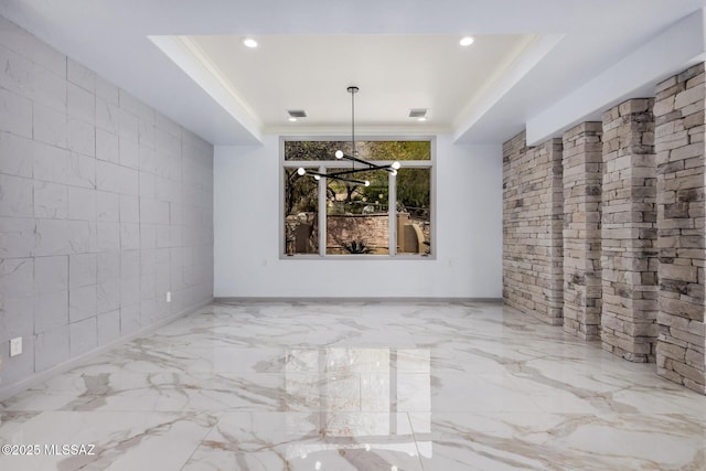 unfurnished dining area with ornamental molding, a notable chandelier, and a tray ceiling