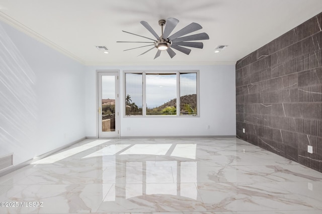 spare room with crown molding, tile walls, and ceiling fan