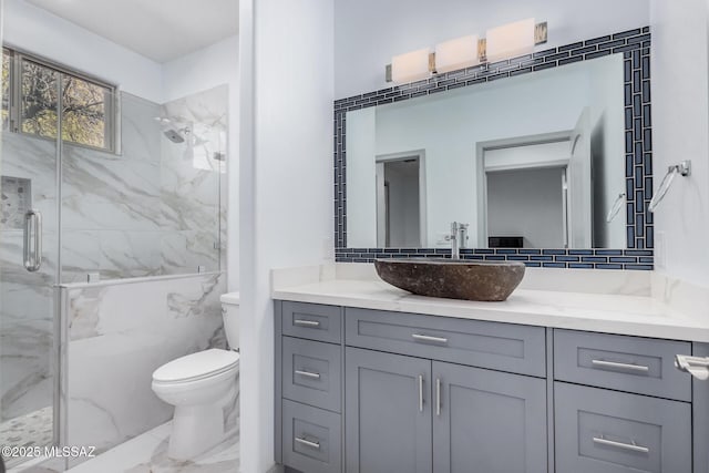 bathroom featuring a shower with door, vanity, and toilet