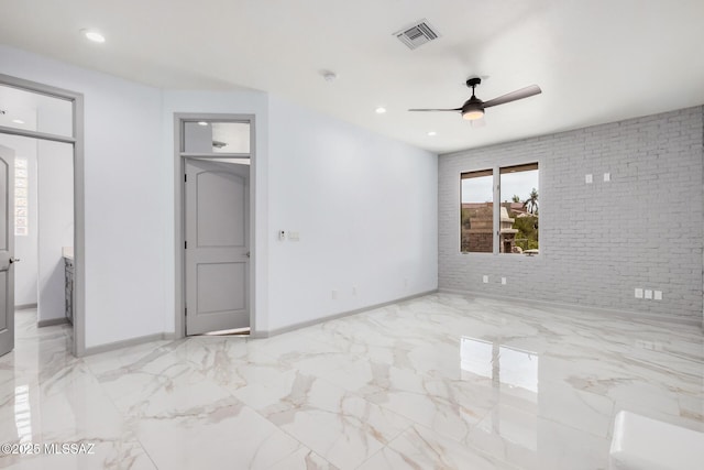 unfurnished bedroom featuring ceiling fan, brick wall, and ensuite bath