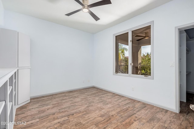 empty room with hardwood / wood-style flooring and ceiling fan