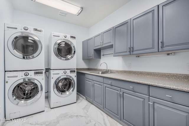 clothes washing area with washer and dryer, sink, cabinets, and stacked washer and clothes dryer