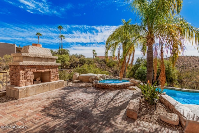 view of patio / terrace featuring a swimming pool with hot tub and an outdoor stone fireplace