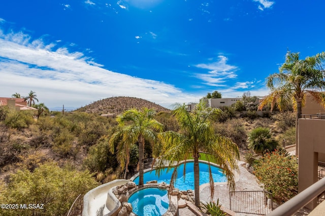 view of pool with a mountain view, a patio area, and an in ground hot tub