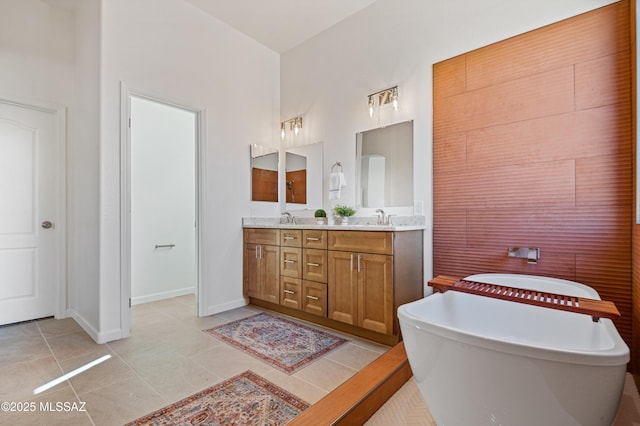 bathroom with tile patterned flooring, vanity, and a bath