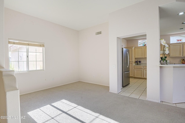 spare room featuring light carpet