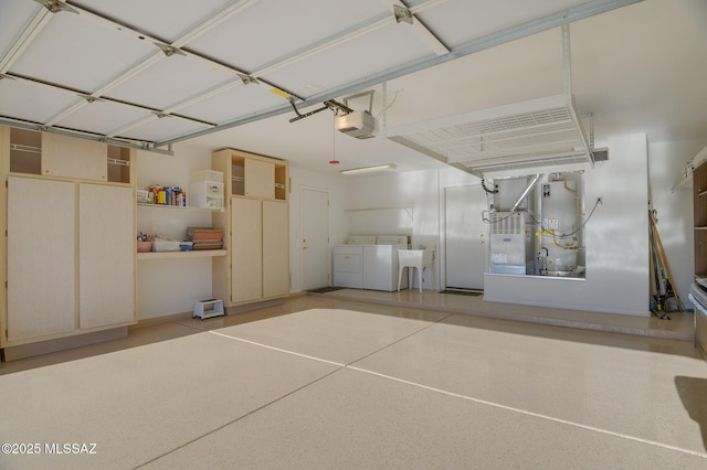 garage with a garage door opener, washing machine and dryer, and water heater