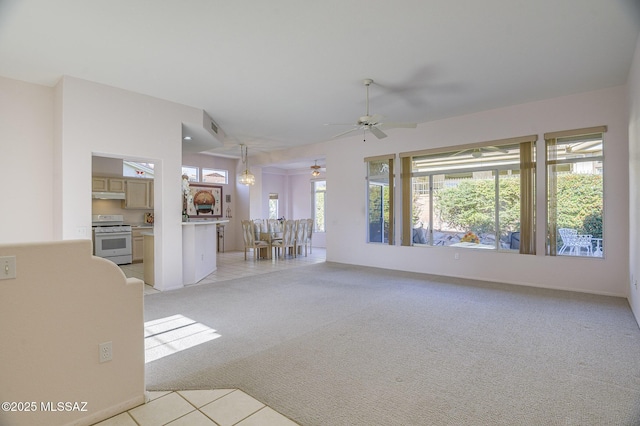 unfurnished living room featuring light carpet and ceiling fan