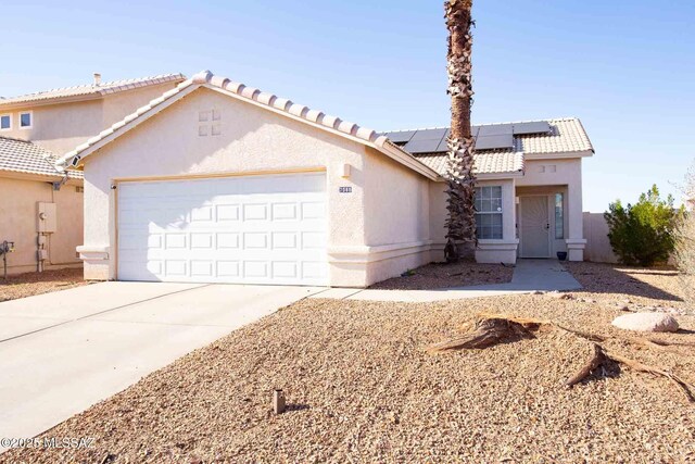 view of front facade with a garage and solar panels