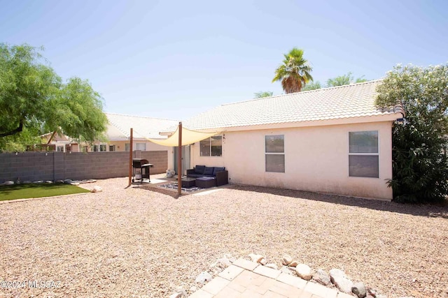 rear view of property with stucco siding, an outdoor hangout area, a patio area, a fenced backyard, and a tiled roof