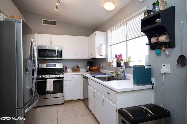 kitchen with stainless steel appliances, light countertops, visible vents, white cabinets, and a sink