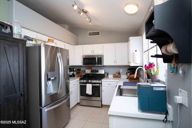 kitchen with light tile patterned floors, appliances with stainless steel finishes, light countertops, white cabinetry, and a sink