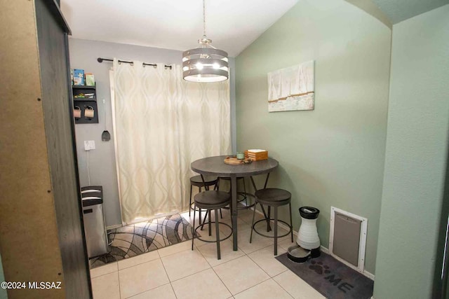 dining room with lofted ceiling and light tile patterned flooring