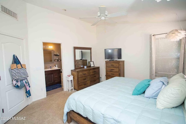 carpeted bedroom with visible vents and ensuite bath