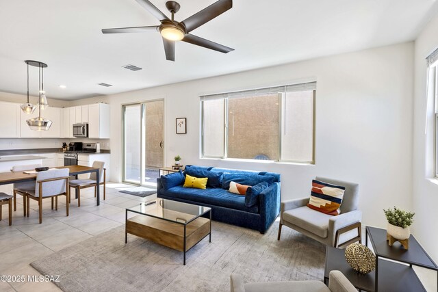 tiled living room featuring a wealth of natural light and ceiling fan