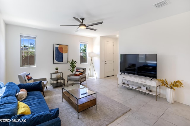 living room with ceiling fan, light tile patterned flooring, visible vents, and a healthy amount of sunlight