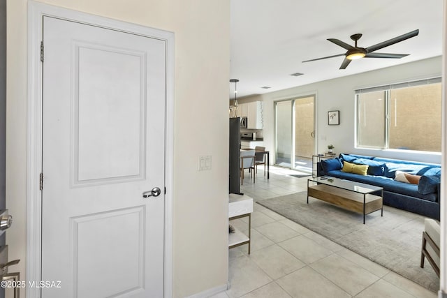 living room with light tile patterned floors, ceiling fan, and visible vents