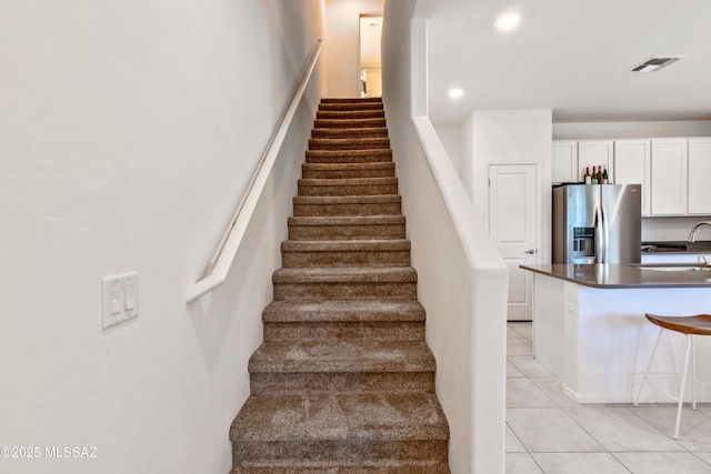 stairs with tile patterned flooring, visible vents, and recessed lighting