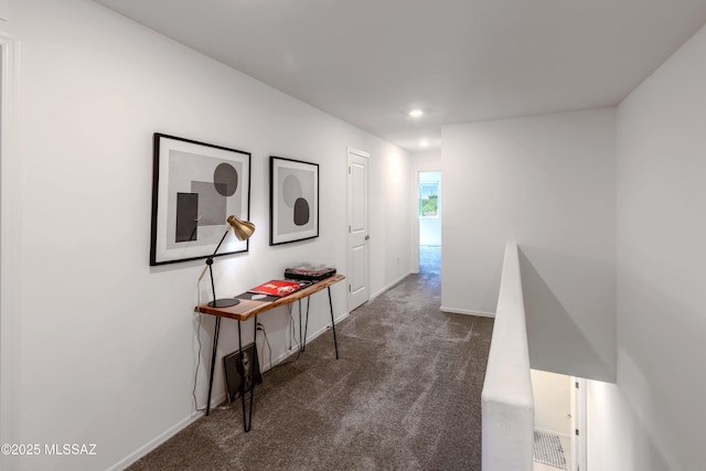 hallway featuring baseboards, dark colored carpet, and recessed lighting