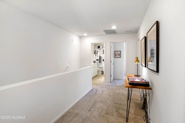 hall featuring recessed lighting, visible vents, light carpet, and baseboards