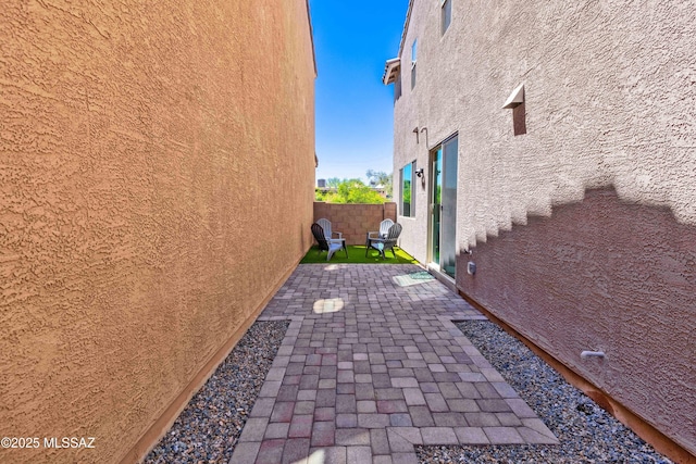 view of property exterior featuring a fenced backyard, a patio, and stucco siding