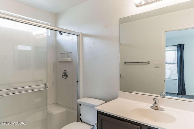 bathroom with vanity, a shower with shower door, and toilet