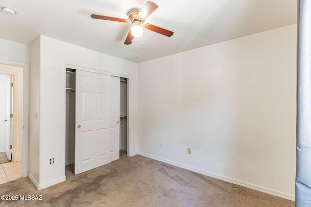 unfurnished bedroom featuring light carpet, a closet, and ceiling fan