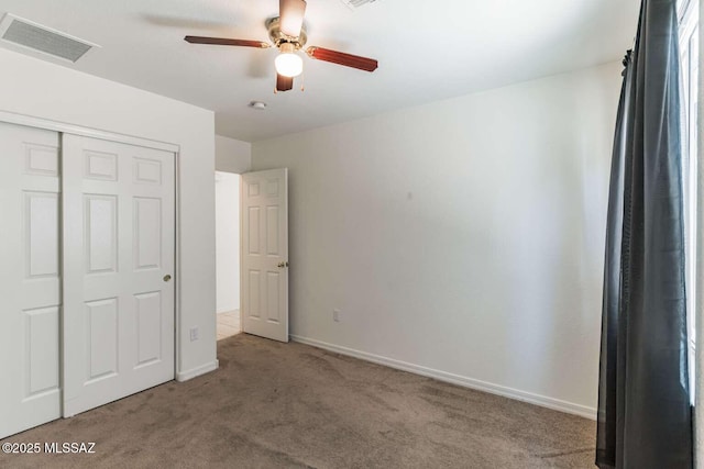 unfurnished bedroom with ceiling fan, light colored carpet, and a closet