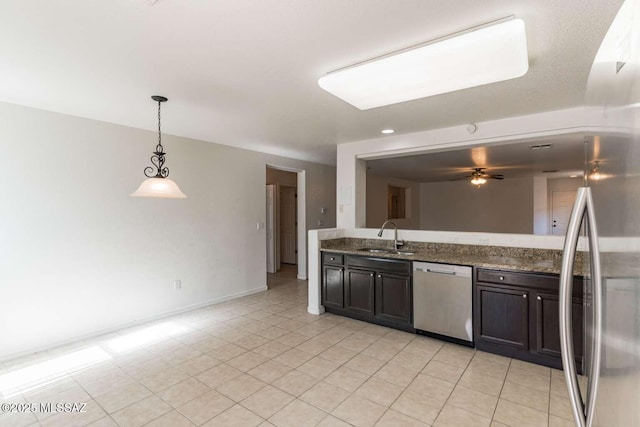 kitchen featuring sink, hanging light fixtures, dark stone counters, ceiling fan, and stainless steel appliances