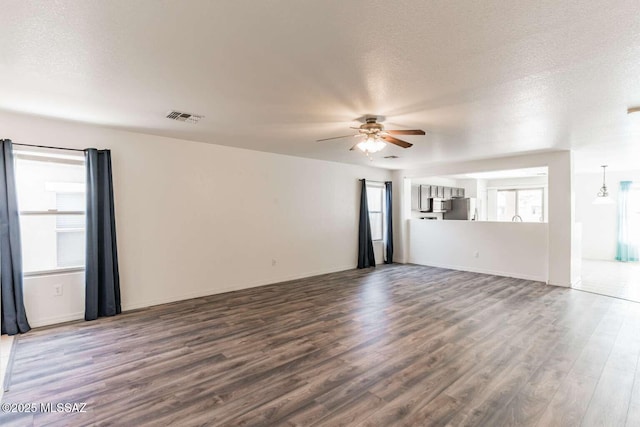 unfurnished room featuring hardwood / wood-style flooring, ceiling fan, and a textured ceiling