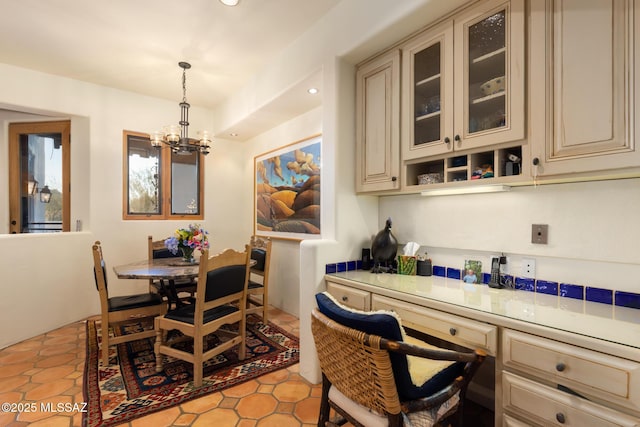 dining space with recessed lighting, light tile patterned floors, built in study area, and an inviting chandelier