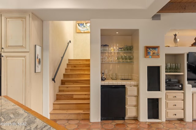 bar featuring light tile patterned flooring, indoor wet bar, stairway, and fridge