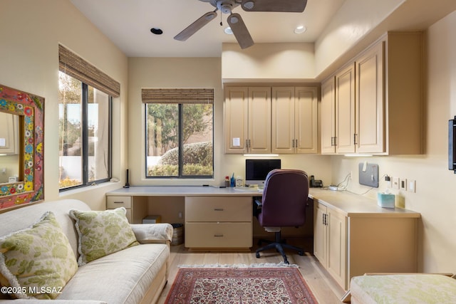 office area with ceiling fan, built in study area, and light wood-style flooring