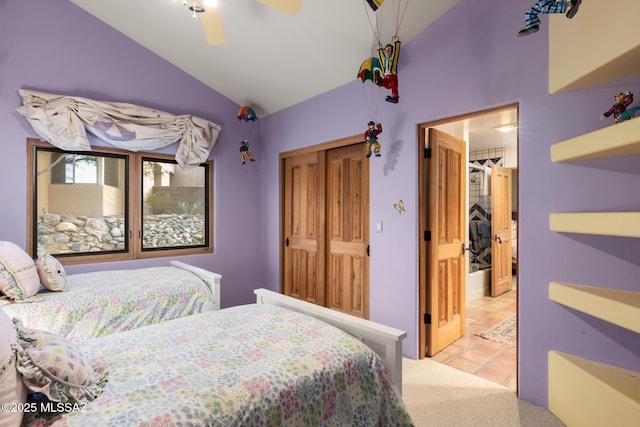 tiled bedroom with a closet, vaulted ceiling, and ceiling fan