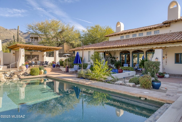 exterior space featuring a patio area, fence, an outdoor pool, and stucco siding