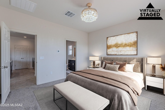 carpeted bedroom with ensuite bathroom and a chandelier