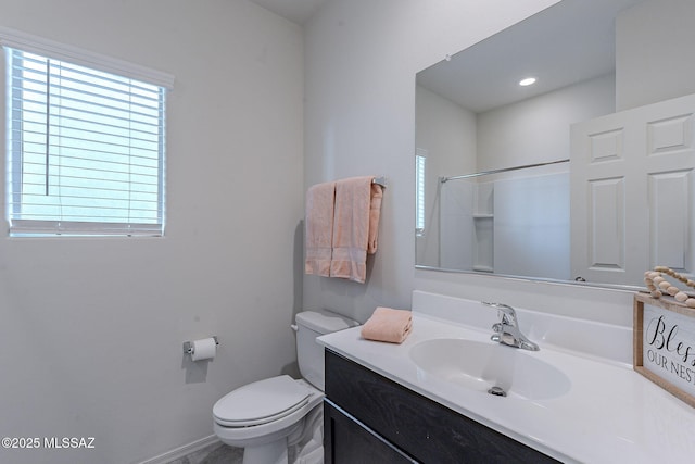 bathroom featuring vanity, toilet, and a shower