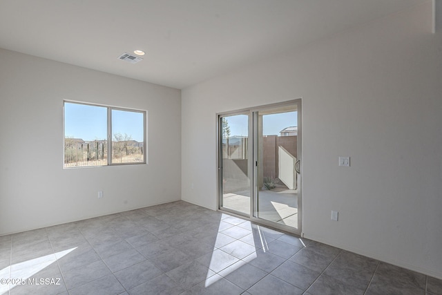 tiled spare room with a healthy amount of sunlight