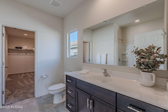 bathroom featuring vanity, tile patterned floors, toilet, and walk in shower